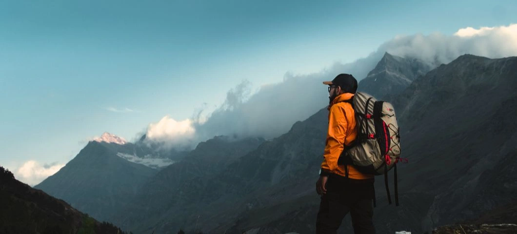 Hiker with Adventure Worx rucksack overlooking mountains.