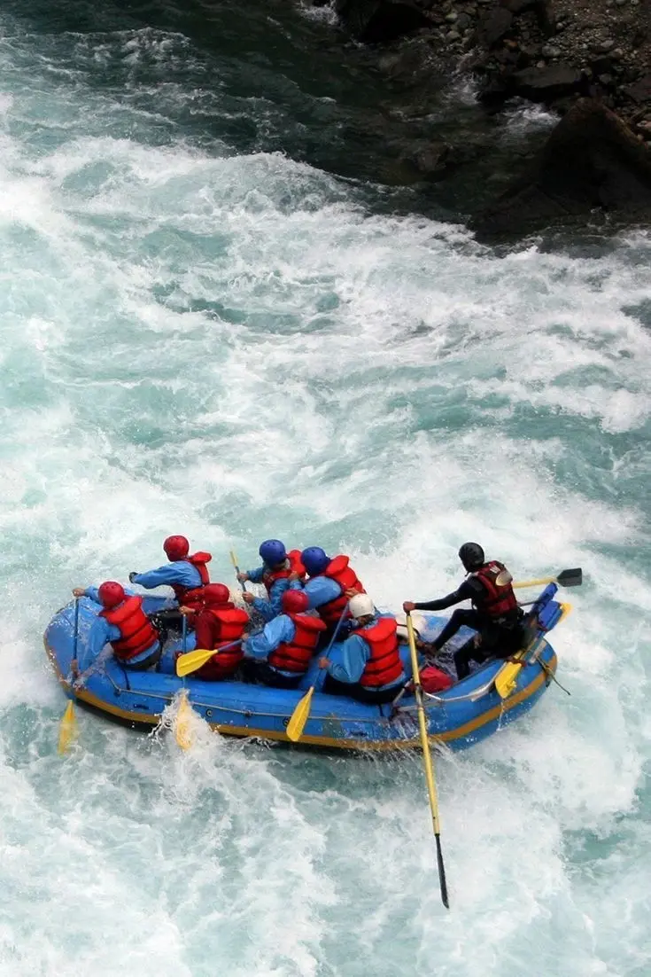 Rafting group navigating river rapids