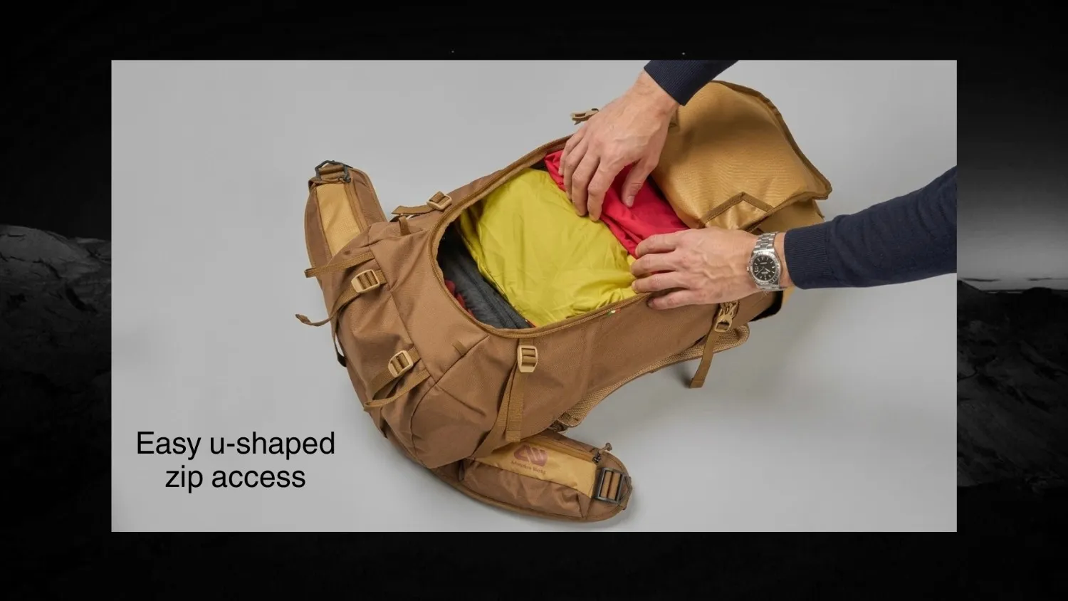 Hands packing a yellow dry bag into a rucksack for travel