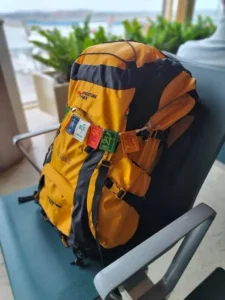 Packed yellow Adventure Worx Xplore 55 rucksack resting on an airport lounge chair